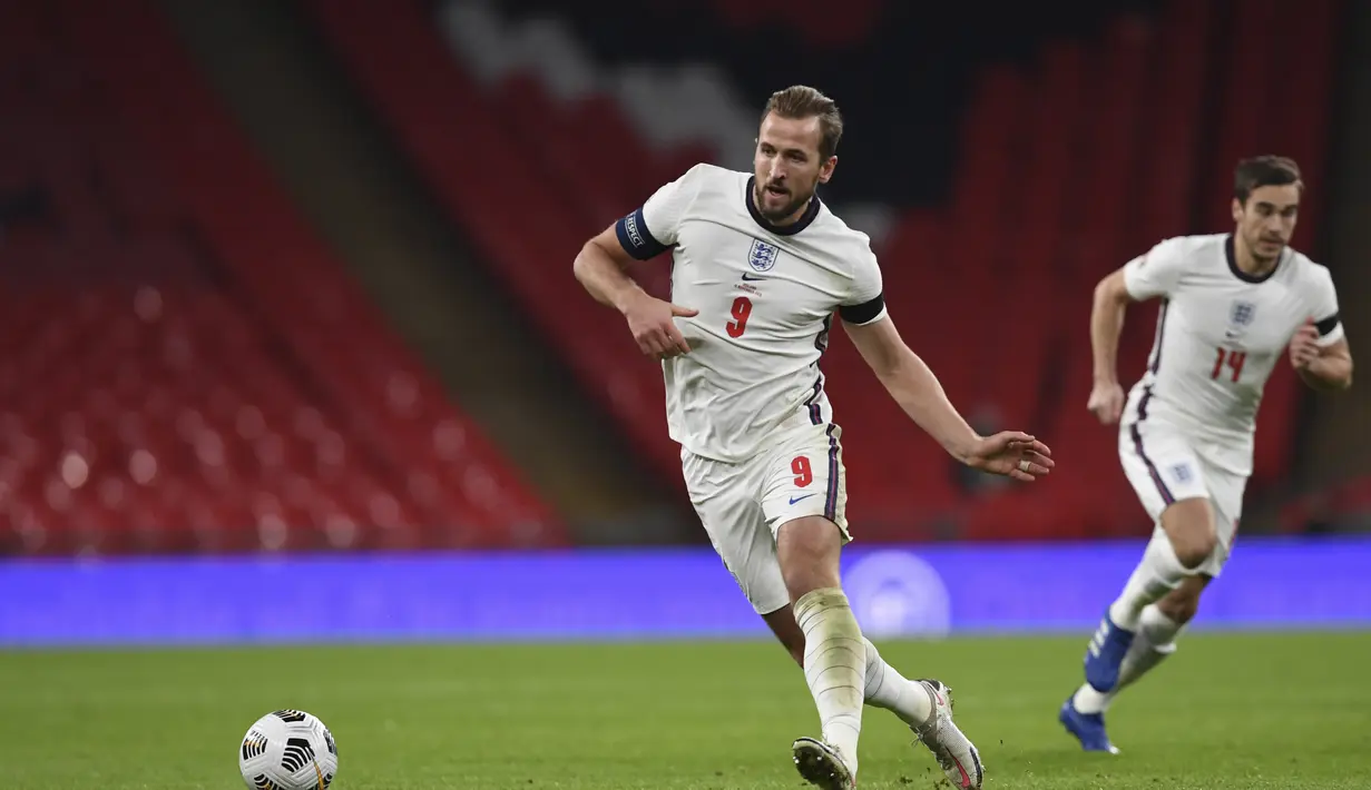 Penyerang Inggris, Harry Kane mengumpan bola saat bertanding melawan Islandia pada pertandingan UEFA Nations League di stadion Wembley, London (18/11/2020). Inggris menang telak 4-0 atas Islandia. (Neil Hall / Pool via AP)