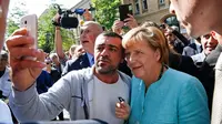 Kanselir Jerman Angela Merkel 'Tokoh Tahun Ini' versi TIME. Bersama pencari suaka Suara yang sampai di Jerman. (Reutes)