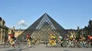Pebalap Kolombia Egan Bernal (tengah) melewati museum piramida Louvre saat mengikuti Tour de France 2019, Paris, Prancis, Minggu (28/7/2019 ). Tour de France 2019 dimulai dari Rambouillet dan berakhir di Paris. (Julien de Rosa/Pool Photo via AP)