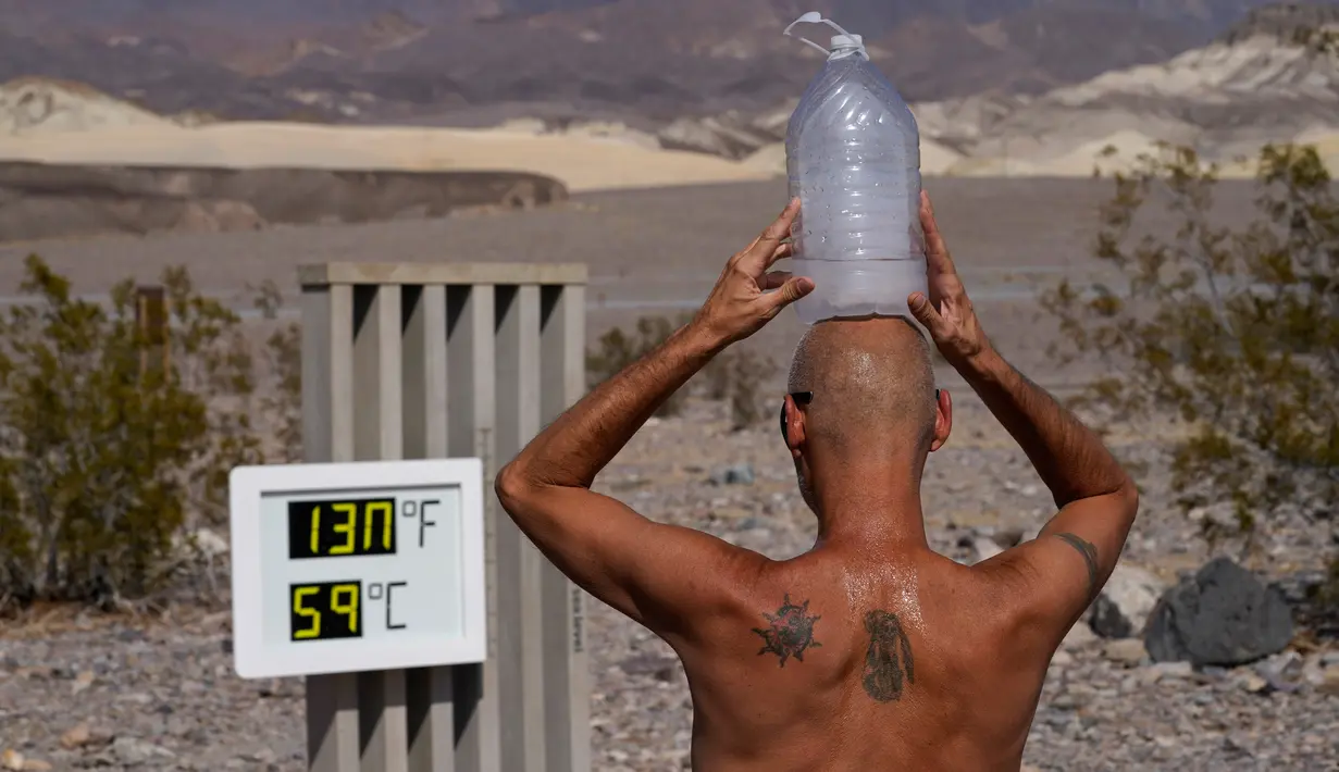 Suhu di Death Valley Capai 54,4 Derajat Celsius: Steve Krofchik mendinginkan kepalanya dengan botol berisi es batu di Taman Nasional Death Valley, California, Senin (17/8/2020). Temperatur udara tertinggi di Dunia -- 54,4 derajat Celcius -- tercatat di Death Valley pada 16 Agustus. (AP/John Locher)