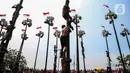 Peserta mengikuti perlombaan panjat pinang di pantai Ancol, Jakarta, Sabtu (17/8/2024). (Liputan6.com/Angga Yuniar)