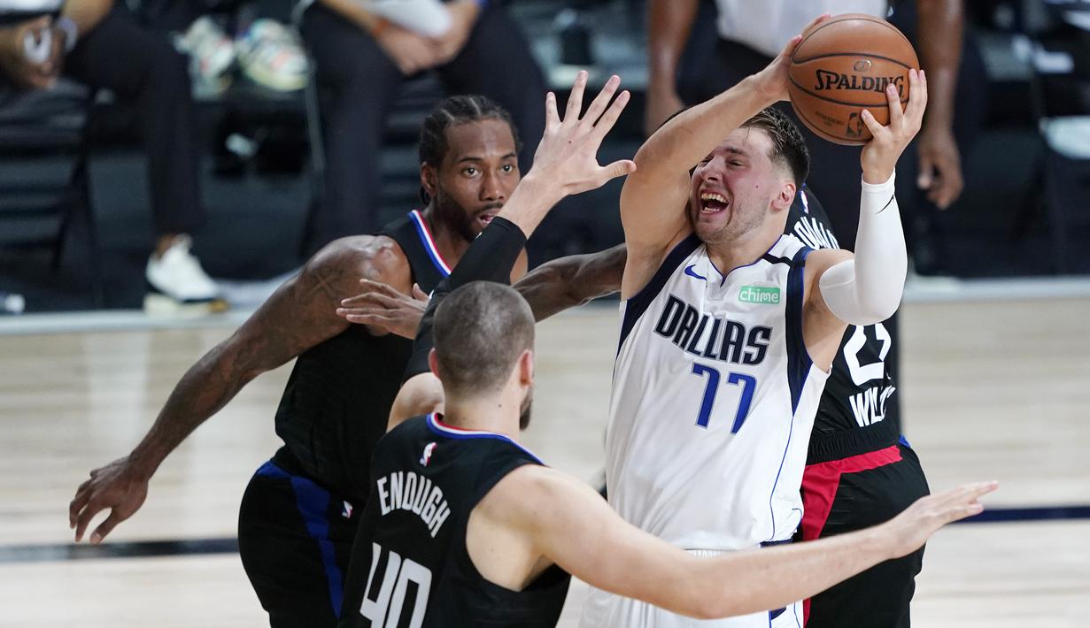 Pebasket Dallas Mavericks, Luka Doncic, berebut bola dengan pemain Los Angeles Clippers pada gim kedua playoff NBA 2020 di AdventHealth Arena, Kamis (20/8/2020). Maverick menang 127-114 atas LA Clipppers. (AFP/Ashley Landis-Pool/Getty Images)