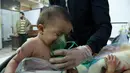 Seorang bayi mendapat bantuan pernapasan usai menghirup senjata kimia di Al-Shifuniyah, Ghouta Timur, Damaskus, Suriah, Minggu (25/2). (HAMZA AL-AJWEH/AFP)
