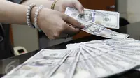Teller menghitung lembaran mata uang dolar AS di penukaran mata uang, Jakarta, Kamis (13/4). Nilai tukar rupiah terpantau menguat 0,09% atau 12 poin ke Rp13.263 per dolar AS di pasar spot. (Liputan6.com/Angga Yuniar)