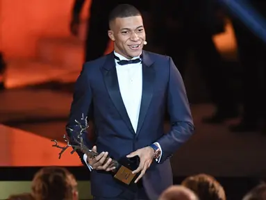 Striker Paris Saint-Germain, Kylian Mbappe setelah menerima penghargaan Trophee Kopa pada seremoni Ballon d'Or 2018 di Grand Palais, Senin (3/12). Ini merupakan penghargaan bagi pesepakbola terbaik yang masih berusia di bawah 21 tahun. (FRANCK FIFE/AFP)