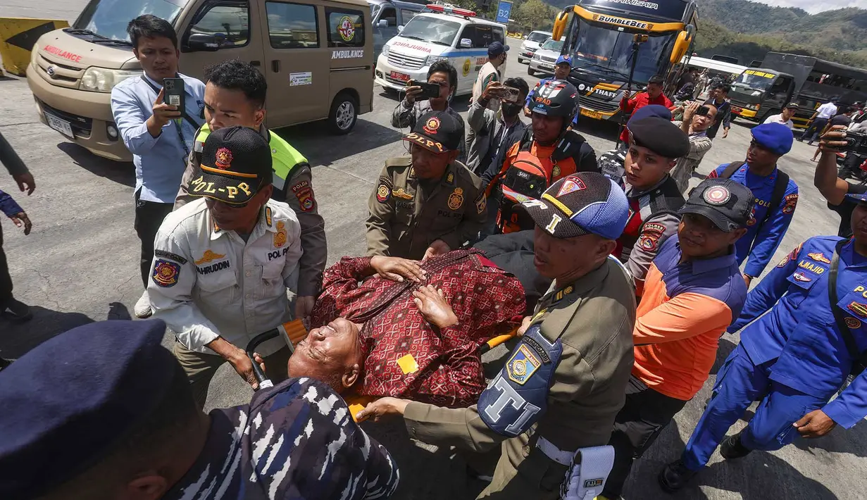 Petugas penyelamat, personel militer, dan polisi membawa penumpang yang telah dievakuasi menggunakan tandu turun dari kapal pencarian dan penyelamatan di Pelabuhan Lembar, Lombok Barat, Rabu, 12 Agustus 2026. (AFP)