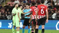 Wasit asal Spanyol Miguel Ortiz mendengarkan headset-nya selama pertandingan sepak bola semifinal Piala Super Spanyol antara Athletic Bilbao dan Barcelona di King Abdullah Sport City di Jeddah pada 8 Januari 2025.FADEL SENNA / AFP