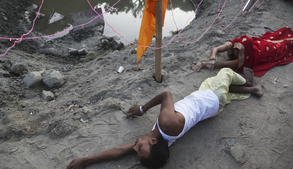 Umat Hindu Nepal bergerak sambil berbaring sujud, sebagai bagian dari ritual, selama festival Chhath Puja di Kathmandu, Nepal, Rabu (10/11/2021). Ritual dilakukan untuk berterima kasih kepada Dewa Matahari karena telah menopang kehidupan di bumi. (AP Photo/Niranjan Shrestha)