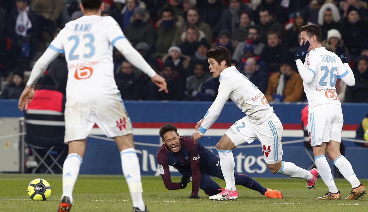 Pemain PSG, Neymar (tengah) jatuh saat berebut bola dengan pemain Marseille pada lanjutan Ligue 1 Prancis di Parc des Princes Stadium, Paris, (25/2/2018). PSG menang 3-0. (AP/Thibault Camus)