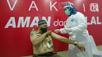 Vaksinator menyuntikkan vaksin COVID-19 kepada guru di SMA 70, Jakarta, Rabu (25/2/2021). Sebanyak 600 orang dari profesi guru, tenaga kependidikan, dan dosen akan divaksin COVID-19 hari ini. (Liputan6.com/Faizal Fanani)