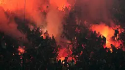 Para suporter Galatasaray menyalapan suar dalam laga lanjutan Liga Super Turki 2025/2026 antara Fenerbahce melawan Galatasaray di Chobani Stadium, Istanbul, Turki, Senin (01/12/2025) waktu setempat. (AP Photo/Khalil Hamra)