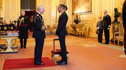 Pembalap Lewis Hamilton berbincang dengan Pangeran Charles setelah menerima gelar kebangsawanan dari Kerajaan Inggris di Kastil Windsor, Rabu (15/12/2021). Sebelumnya Lewis telah menerima gelar kebangsawanan Member of British Empire atau MBE pada 2009. (Dominic Lipinski/PA via AP)