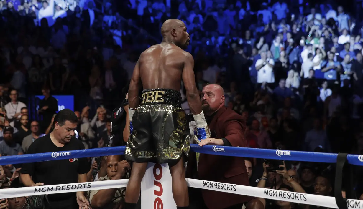 Gaya Floyd Mayweather Jr. merayakan kemenangannya atas Conor McGregor pada gelaran Tinju Dunia super welterweight boxing di MGM Arena, Las Vegas, (26/8/2017). Mayweather menang TKO atas McGregor. (AP/Isaac Brekken)