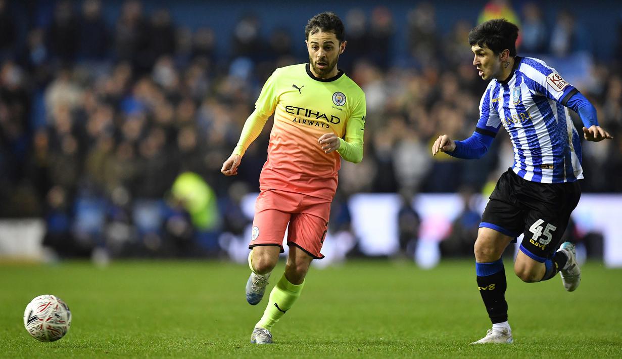 Gelandang Manchester City, Bernardo Silva, berebut bola dengan striker Sheffield Wednesday, Fernando Forestieri, pada laga babak kelima Piala FA di Hillsborough Stadium, Rabu (4/3) malam waktu setempat. Manchester City menang 1-0 atas Sheffield. (AFP/Paul Ellis)
