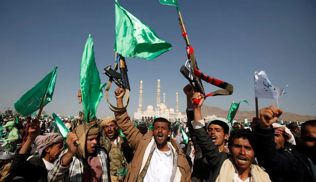 Sejumlah orang membawa senjata dan bendera saat mengikuti peringatan hari kelahiran Nabi Muhammad di Sanaa, Yaman (11/12). Mereka menghadiri acara tersebut membawa spanduk-spanduk besar yang berisi slogan peringatan Maulid Nabi.  (Reuters/Khaled Abdullah)