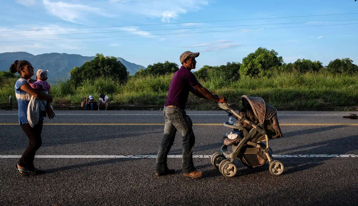 Seorang imigran Honduras mendorong kereta bayi dalam perjalanannya menuju Amerika Serikat di negara bagian Oaxaca, Meksiko, 29 Oktober 2018. Kereta dorong bayi telah menjadi barang mewah bagi para imigran dalam perjalanan mereka. (Guillermo Arias/AFP)
