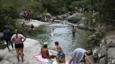 Wisatawan menikmati kolam alami Polischellu di hutan Bavella di celah Bavella dekat Zonza di selatan pulau Corsica, Mediterania Prancis (25/8/2021).  Situs Bavella penuh sesak dengan turis selama musim panas. (AFP/Pascal Pochard-Casabianca)