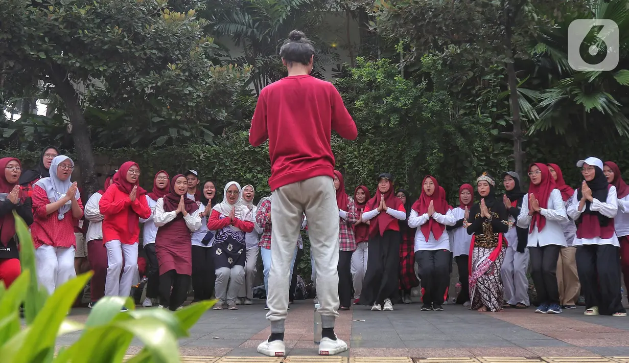 Sejumlah mahasiswa melakukan paduan suara dan gerak tari saat Car Free Day, di Jakarta, Minggu (25/9/2022). Pagelaran ini merupakan bentuk pengenalan seni kepada masyarakat yang tengah melakukan aktivitas di CFD. (Liputan6.com/Angga Yuniar)