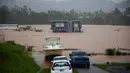 Sebuah rumah terendam banjir akibat Badai Fiona di Cayey, Puerto Rico, Minggu, 18 September 2022. Menurut pihak berwenang, tiga orang berada di dalam rumah dan dilaporkan telah diselamatkan. (AP Photo/Stephanie Rojas)
