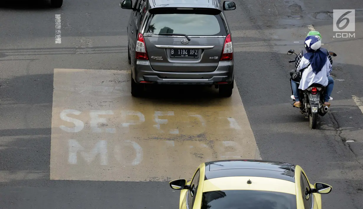 Pengendara motor melintas di Jalan MH. Thamrin, Jakarta, Minggu (4/2). Ada enam titik dari 10 titik yang telah diberikan marka kuning sebagai penanda jalur khusus sepeda motor. (Liputan6.com/Faizal Fanani)