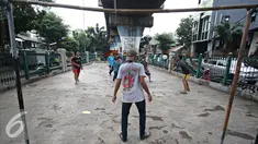 Sejumlah remaja bermain sepak bola di kolong rel kereta kawasan Juanda, Jakarta, Jumat (27/5). Tidak tersedianya ruang terbuka menyebabkan lahan tersebut dijadikan tempat bersosialisasi bagi warga. (Liputan6.com/Immanuel Antonius)