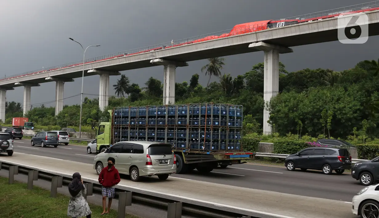 Kendaraan melintas di bawah kereta ringan lintas rel terpadu (LRT) Jabodebek yang mengalami kecelakaan di jalur lintas LRT Cibubur, Jakarta Timur, Senin (25/10/2021). Dua kereta LRT tersebut sedang uji coba saat tabrakan terjadi sehingga gerbong kosong. (Liputan6.com/Herman Zakharia)
