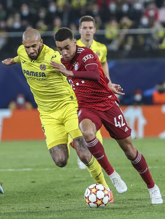 Gelandang Bayern Munchen, Jamal Musiala berusaha melewati pemain Villarreal, Etienne Capoue pada pertandingan leg pertama perempat final Liga Champions di stadion La Ceramica di Vila-real, Kamis (7/4/2022). Villarreal menang tipis atas Bayern Munchen 1-0. (AP Photo/Alberto Saiz)