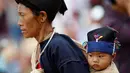 Seorang ibu menggendong buah hatinya saat berjalan-jalan di desa Pansang, wilayah pemberontak Wa, di Myanmar, 3 Oktober 2016. (REUTERS/Soe Zeya Tun)