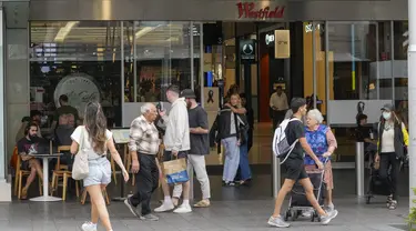 Orang-orang berjalan di luar pusat perbelanjaan Westfield di Bondi Junction di Sydney, Jumat (19/4/2024). Pusat perbelanjaan tersebut dibuka kembali untuk bisnis pada hari Jumat untuk pertama kalinya sejak menjadi lokasi penikaman massal yang menewaskan enam orang pada Sabtu, 13 April lalu. (AP Photo/Mark Baker)