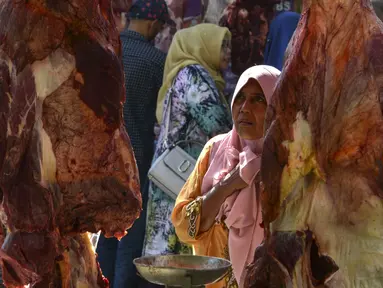 Seorang wanita Aceh berbelanja daging pada perayaan tradisi Meugang Ramadan 1440 Hijriah di pasar tradisional di Banda Aceh, 4 Mei 2019. Meugang merupakan tradisi turun temurun masyarakat Aceh dengan membeli, mengolah, hingga menyantap daging bersama keluarga. (CHAIDEER MAHYUDDIN/AFP)