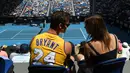 Seorang penonton mengenakan jersey basket Kobe Bryant saat menyaksikan pertandingan antara petenis Rumania, Simona Halep dengan Elise Mertens dari Belgia pada babak kedelapan Australia Terbuka 2020 di Melbourne, Senin (27/1/2020).  (Greg Wood/AFP)