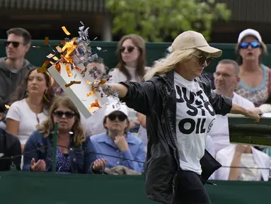 Seorang pengunjuk rasa Just Stop Oil berlari ke Court 18 dan melepaskan confetti pada hari ketiga kejuaraan tenis Wimbledon di London, Rabu, 5 Juli 2023. (AP Photo/Alastair Grant)