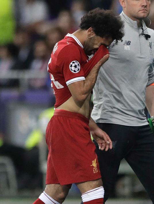 Pemain depan Liverpool Mohamed Salah meninggalkan lapangan sambil menangis usai cedera saat melawan Real Madrid dalam pertandingan final Liga Champions di Stadion NSK Olimpiyskiy, Ukraina (26/5). (AP / Matthias Schrader)