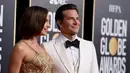 Irina Shayk dan aktor Bradley Cooper berpose saat menghadiri Golden Globe Awards ke-76 di Beverly Hills, California (6/1). Irina tampil mengenakan gaun emas. Sedangkan Bradley Cooper tampil dengan tuksedo putih. (AP Photo/Jordan Strauss)