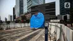 Suasana Proyek Pembangunan tugu sepeda di Jalan Jenderal Sudirman, Jakarta, Rabu (30/3/2022). Tugu yang dulu sempat boming dan digembar-gemborkan kini terlihat terhenti pengerjaannya dan hanya ditutup terpal. (Liputa6.com/Johan Tallo)