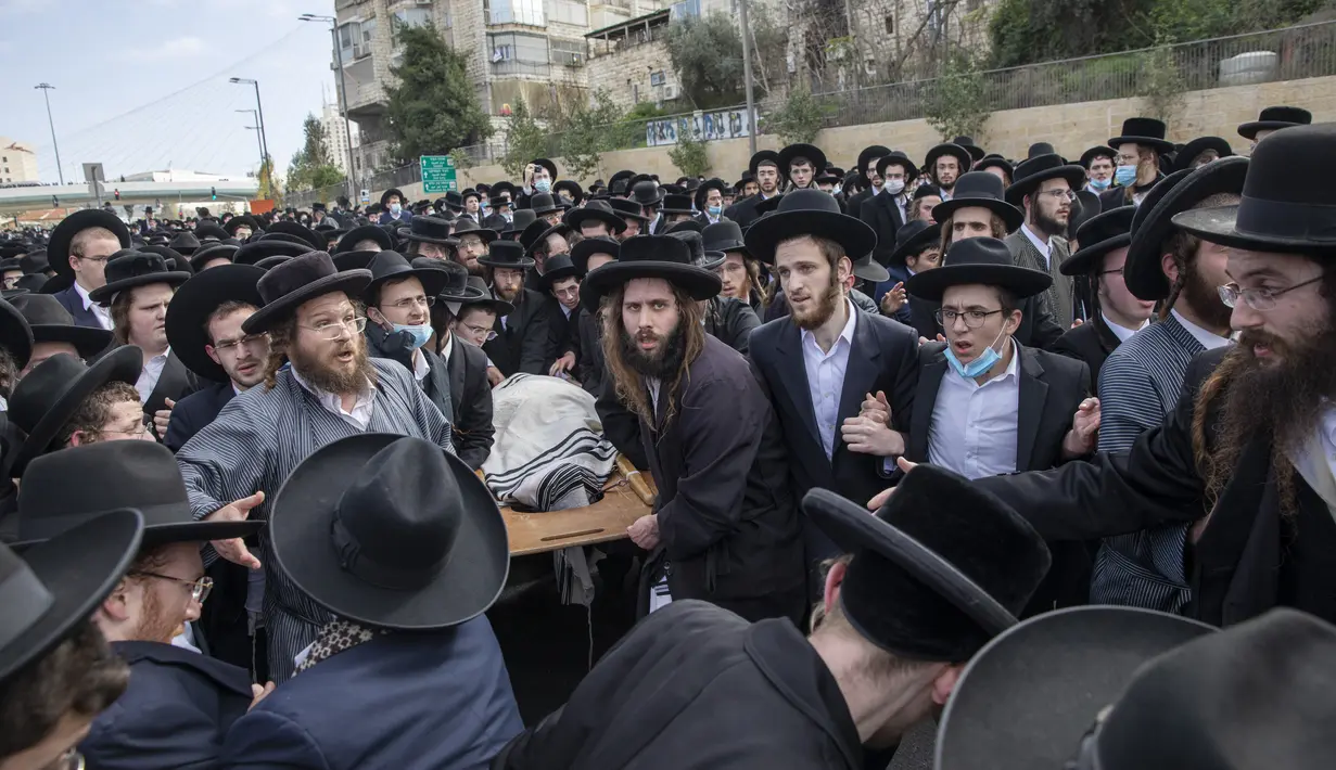 Yahudi ultra-Ortodoks membawa jenazah rabbi terkemuka Meshulam Soloveitchik selama pemakamannya di Yerusalem, Minggu (31/1/2021). Rabi Meshulam Dovid Soloveitchik meninggal pada usia 99 tahun usai terpapar virus corona. (AP Photo/Ariel Schalit