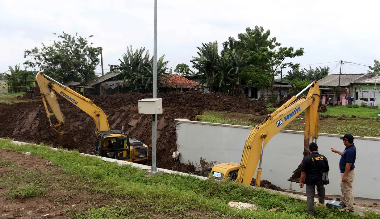 Alat berat dikerahkan saat Puslabpor Bareskrim Polri melakukan olah TKP longsornya Underpass Perimeter Selatan, Bandara Soekarno Hatta (Soetta), Tangerang, Banten, Selasa (6/2). Petugas memasang garis polisi di lokasi longsor. (Liputan6.com/Angga Yuniar)