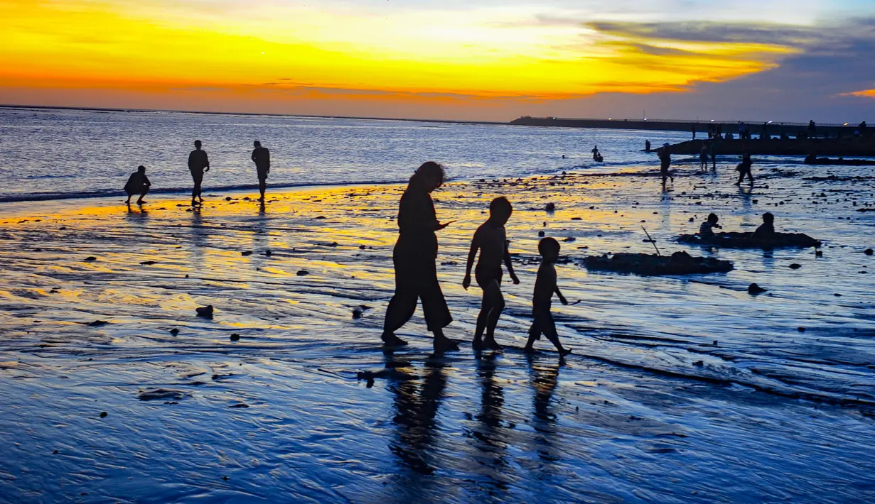 Pantai Kelan terbuka sepanjang waktu dan tidak mengenakan tiket masuk. Pengunjung hanya perlu membayar tarif parkir, yakni Rp2.000 untuk sepeda motor dan Rp5.000 untuk mobil. Meski dapat dikunjungi kapan saja, waktu terbaik menikmati pantai ini adalah pada sore hari saat panorama matahari terbenam menampilkan pesonanya yang paling memukau. Tampak dalam foto, aktivitas wisatawan menikmati waktu senja di Pantai Kelan, Badung, Bali. (merdeka.com/Arie Basuki)