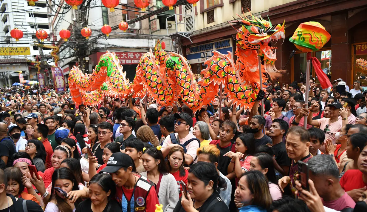 Rombongan tarian naga bergerak melewati kerumunan orang di sepanjang jalan selama perayaan di distrik Chinatown, Manila, pada tanggal 10 Februari 2024. (Ted ALJIBE/AFP)