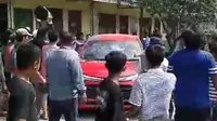 Mobil minibus merah berplat B 1425 UIS diamuk warga sekitar lantaran menghalangi jalan armada damkar menuju lokasi kebakaran di gudang limbah plastik, Kalibaru, Kota Bekasi. (Liputan6.com/Bam Sinulingga)