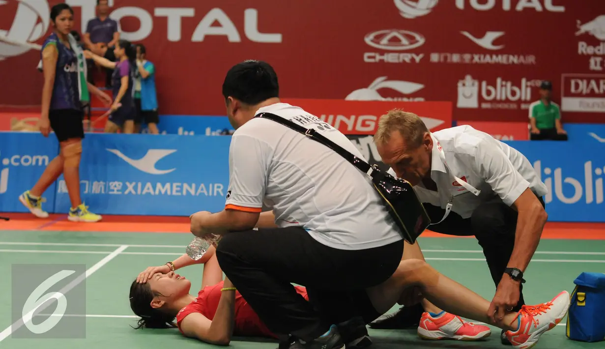 Tim medis memberikan pertolongan buat pebulutangkis Thailand, Ratchanok Intanon saat berlaga melawan Lindaweni Fanetri (Indonesia) di Total BWF Championships 2015 di Jakarta, Kamis (13/8/2015). (Liputan6.com/Helmi Fithriansyah)