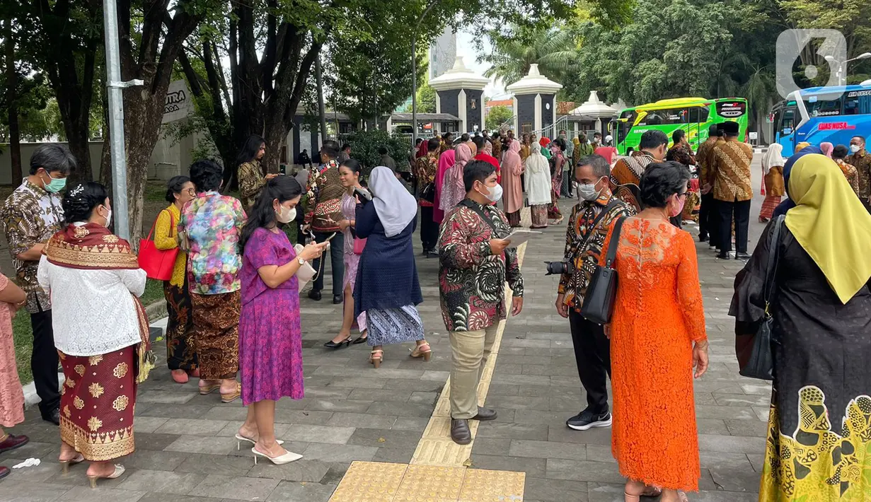 Sejumlah tamu menunggu bus yang akan mengangkut mereka menuju resepsi pernikahan putra bungsu Presiden Jokowi, Kaesang Pangarep dan Erina Gudono dari Stadion Manahan, Solo, Jawa Tengah, Minggu (11/12/2022). Setelah turun dari bus, para tamu langsung berjalan kaki menuju tempat pengecekan tamu undangan di sebelah barat pintu masuk Pura Mangkunegaran. (Liputan6.com/Herman Zakharia)