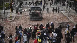Pengunjuk rasa antipemerintah bentrok dengan polisi di Madrid, di pinggiran Bogota, Kolombia (28/5/2021). Warga Kolombia telah turun ke jalan selama berminggu-minggu setelah pemerintah mengusulkan kenaikan pajak pada layanan publik, bahan bakar, upah dan pensiun. (AP Photo/Ivan Valencia)