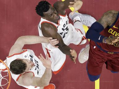 Aksi pemain Cleveland Cavaliers, LeBron James  mencoba melewati adangan dua pemain Toronto Raptors pada lanjutan NBA basketball game di Quicken Loans Arena, (21/3/2018) Cleveland. Cavs menang 132-129. (AP/Tony Dejak)