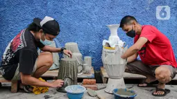 Anak-anak muda menyelesaikan pembuatan pot tanaman berbahan dasar kain bekas di  Cibodas, Kota Tangerang, Minggu (3/10/2021). Para pemuda ini memanfaatkan PPKM untuk membuat Pot tanaman daur ulang yang dipasarkan mulai harga Rp. 30 ribu hingga Rp. 80 ribu. (Liputan6.com/Angga Yuniar)