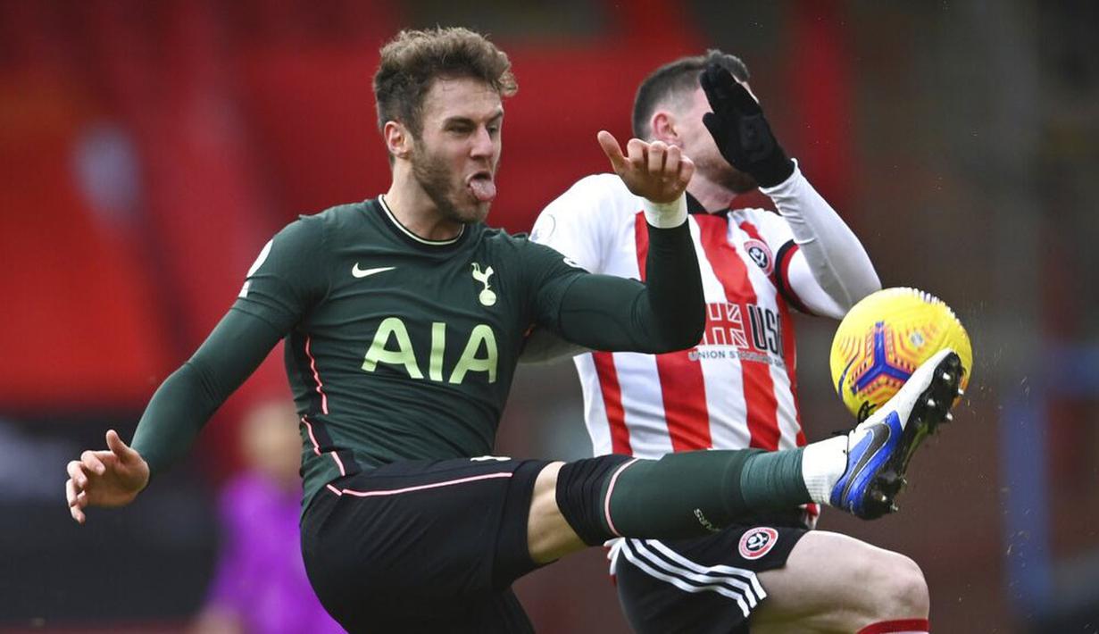 Pemain Tottenham Hotspur, Joe Rodon, berebut bola dengan pemain Sheffield United, Oliver Burke, pada laga Liga Inggris di Stadion Bramall Lane, Minggu (17/1/2021). Tottenham Hotspur menang dengan skor 3-1. (Laurence Griffiths/Pool via AP)