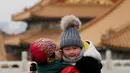 Seorang anak tersenyum saat melakukan tur ke Kota Terlarang di Beijing, (7/3). Kota Terlarang, merupakan istana terisolasi kaisar Qing dan Dinasti Ming China untuk tempat wisata utama yang terletak di pusat ibu kota. (AP Photo/Aijaz Rahi)