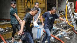 Pedagang menyelamatkan barang dagangan saat proses pendinginan oleh damkar dari kebakaran di Pasar Pagi Asemka, Jakarta, Jumat (18/11/2022). Menurut Kepala Sektor Tambora Sudin Gulkarmat Jakarta Barat, Joko Susilo, api menghanguskan sekitar 20 lapak pedagang. (Liputan6.com/Faizal Fanani)