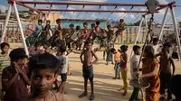 Anak-anak pengungsi Rohingya bermain ayunan di taman bermain di kamp pengungsi Thangkhali, dekat Cox's Bazar, Bangladesh, Kamis (9/8). (Ed JONES/AFP)