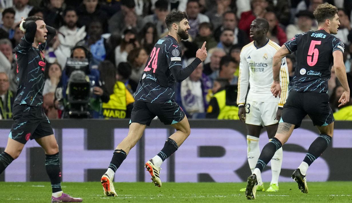 Selebrasi bek Manchester City, Josko Gvardiol (tengah) setelah mencetak gol ketiga timnya ke gawang Real Madrid pada laga leg pertama babak perempatfinal Liga Champions 2023/2024 di Santiago Bernabeu Stadium, Selasa (9/4/2024) malam. (AP Photo/Manu Fernandez)